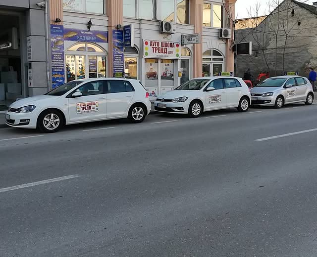 Kancelarija Auto škole Trend u Cara Dušana 28 i tri bela automobila za obuku ispred nje.
